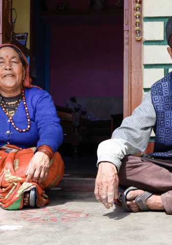 Chander Ram and his wife Haruli Devi standing in front of their stone and tin house in Sarmoli village, which they built after a landslide destroyed their home in Sai village.