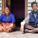 Chander Ram and his wife Haruli Devi standing in front of their stone and tin house in Sarmoli village, which they built after a landslide destroyed their home in Sai village.