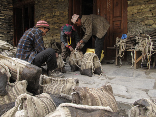 Traders preparing to load goods onto a horse using a Karbach, a traditional saddlebag, in the Johar Valley.